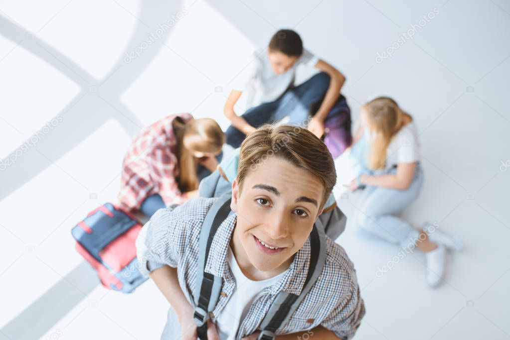 miling teenage boy with backpack