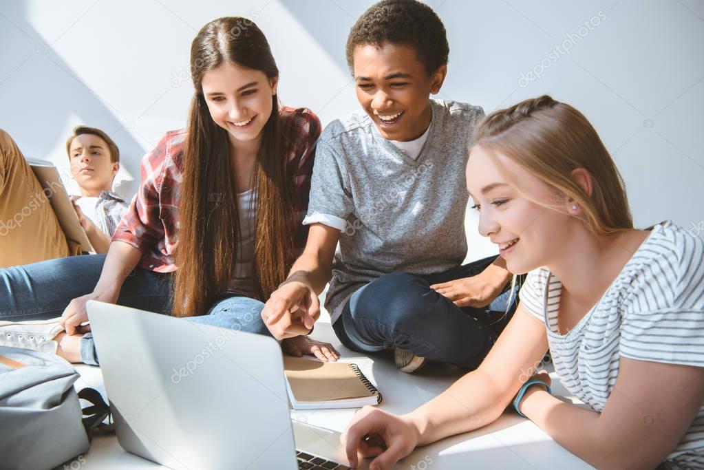 multicultural teenagers with laptop