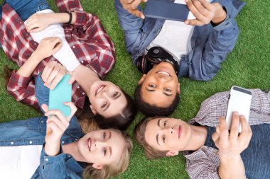 multiethnic teenagers with smartphones clipart