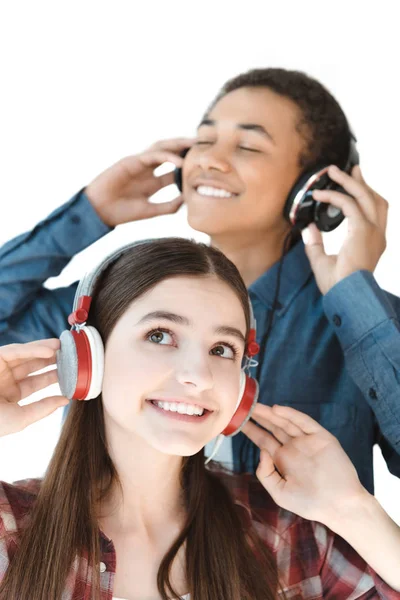 Adolescentes multiétnicos escuchando música en auriculares —  Fotos de Stock