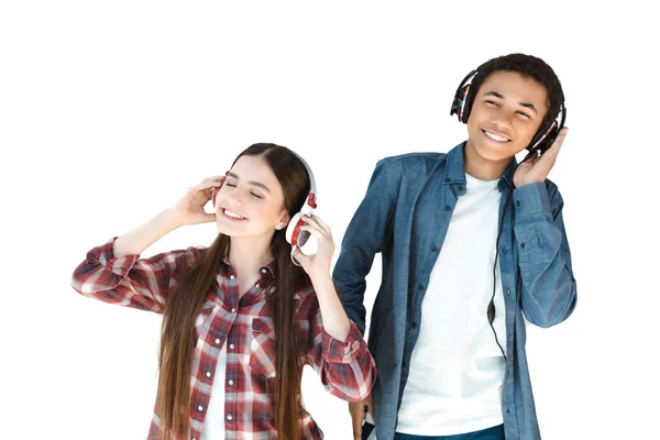 Adolescentes multiétnicos escuchando música en auriculares —  Fotos de Stock