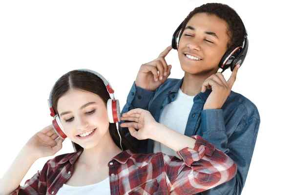 Adolescentes multiétnicos escuchando música en auriculares —  Fotos de Stock