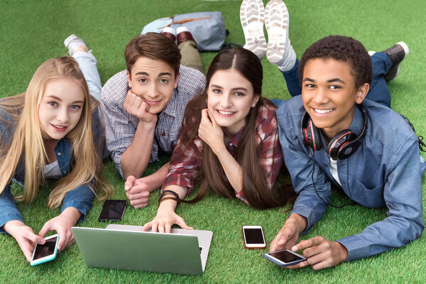 multicultural teenagers using laptop