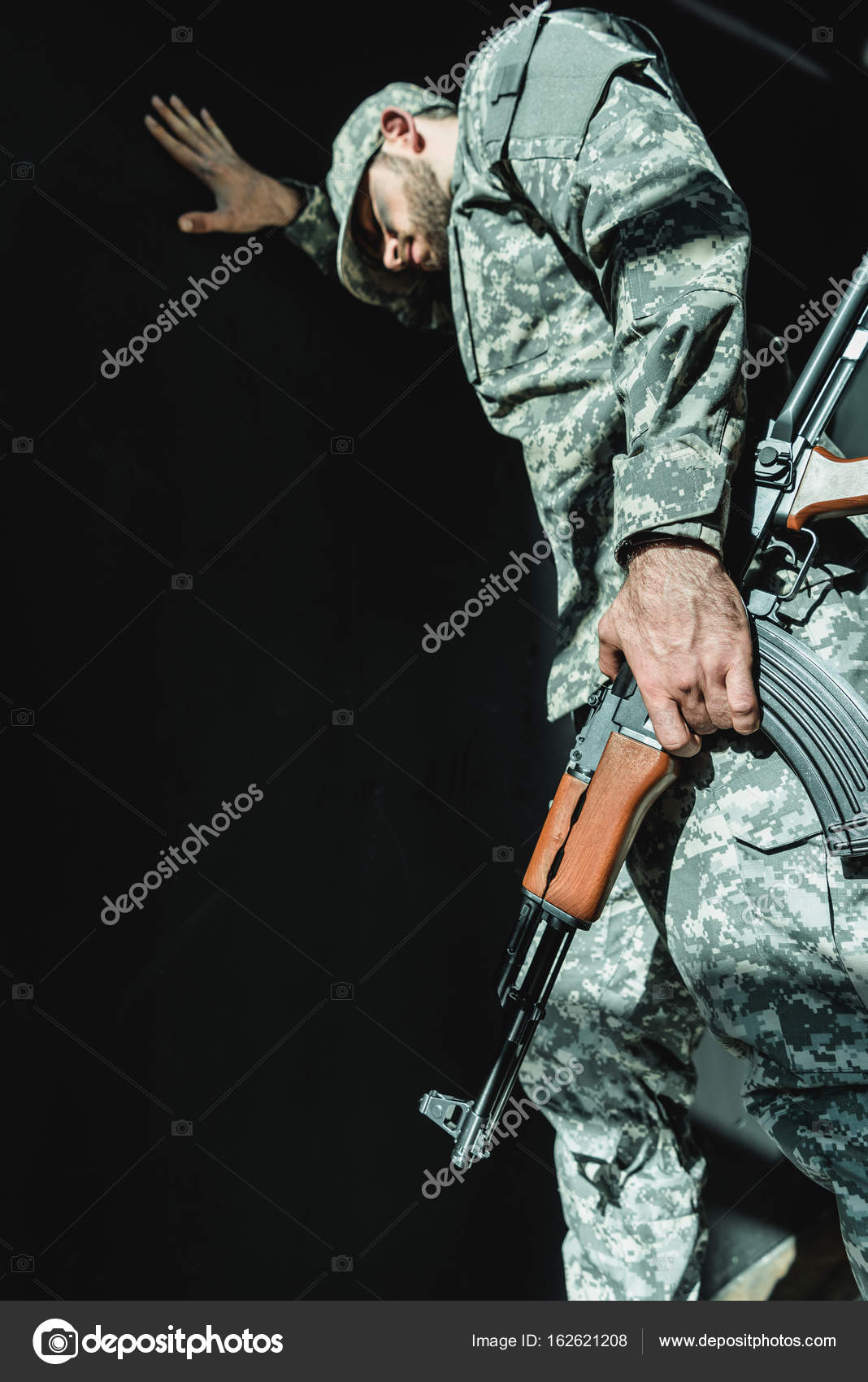 Скорбящий Солдат, Прислонившийся К Стене Стоковое Фото.