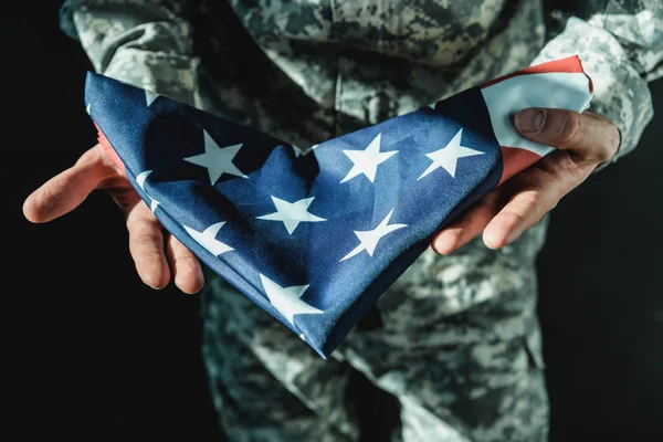 Soldado segurando bandeira EUA dobrado — Fotografia de Stock