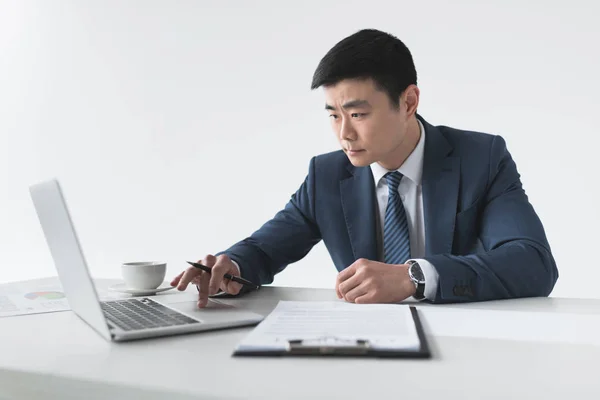 Азиатский бизнесмен с ноутбуком на рабочем месте — стоковое фото