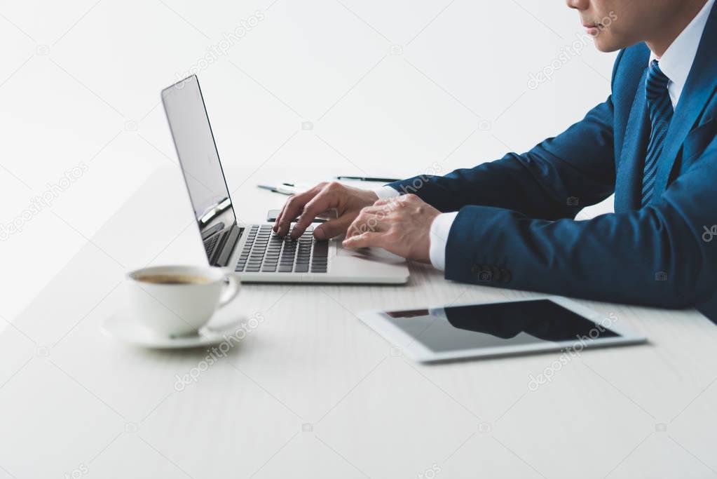 businessman typing on laptop at workplace