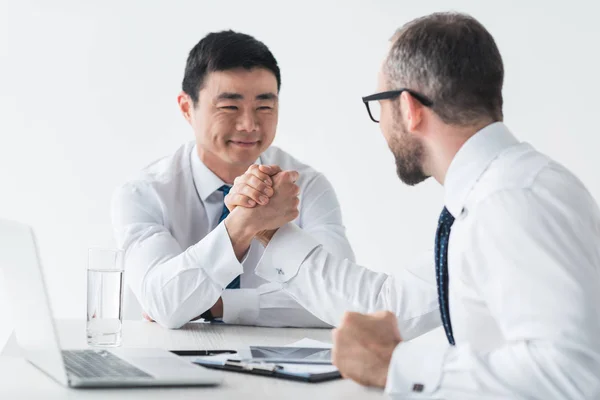 Hombres de negocios multiculturales estrechando la mano en la reunión — Foto de Stock