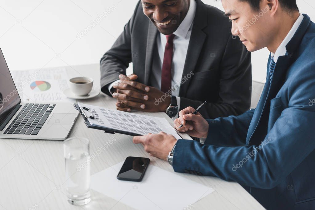 multiethnic businessmen discussing contract