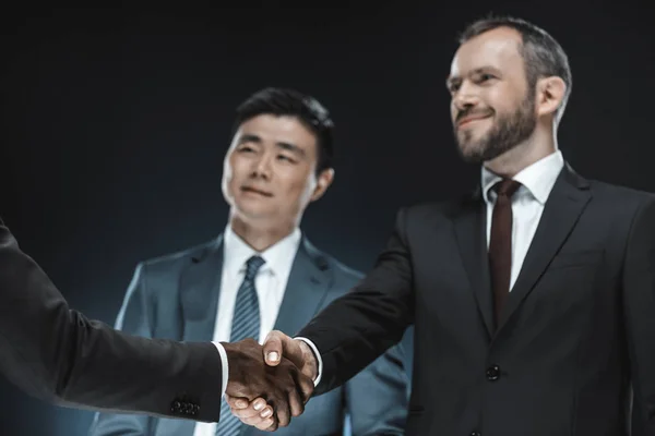 Multi-etnisch zakenpartners handen schudden — Stockfoto