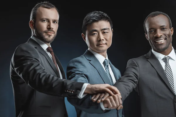 Мультиэтнические бизнесмены держатся за руки — стоковое фото
