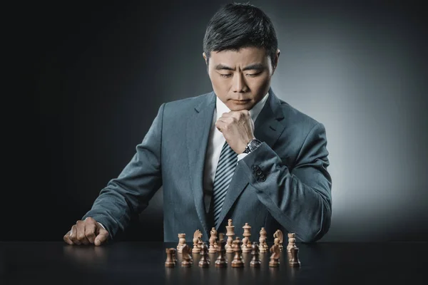 Asian businessman and chess pieces — Stock Photo, Image