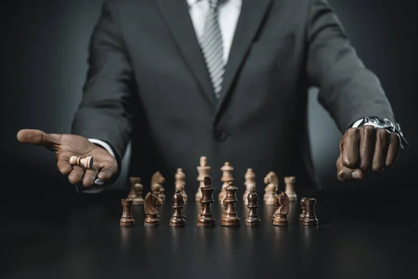 チェス図を保持しているアフリカ系アメリカ人のビジネスマン — ストック写真