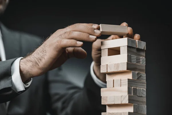 Homem de negócios jogando blocos de madeira jogo — Fotografia de Stock