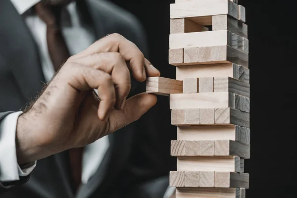 Uomo d'affari giocando blocchi di legno gioco — Foto Stock