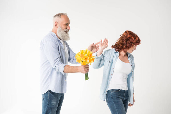 man with bouquet and dissatisfied wife
