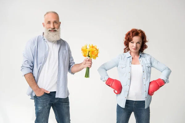 Woman in boxing gloves and husband with bouquet — Stock Photo, Image