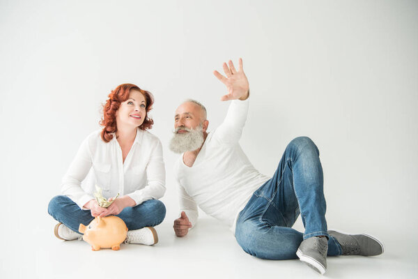 Pareja con dólares y alcancía — Foto de Stock