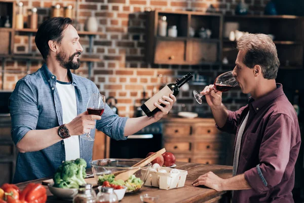 A férfiak bort iszik a konyhában — Stock Fotó