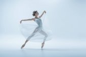 elegante Ballerina im weißen Kleid, die im Studio tanzt, isoliert auf Weiß