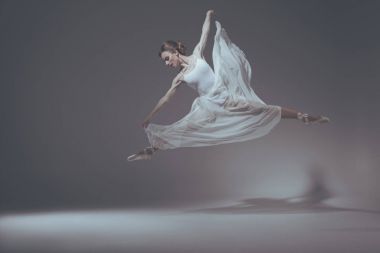 Beyaz elbiseli atlama güzel bale dansçısı