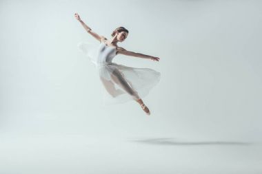 elegant ballet dancer in white dress jumping in studio, isolated on white clipart