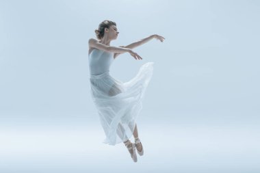Studio, üzerinde beyaz izole atlama beyaz elbiseli genç balerin