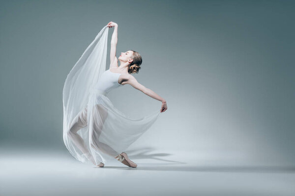 attractive ballerina dancing in white dress