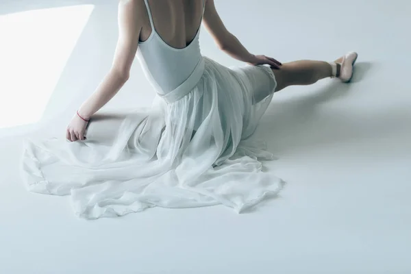 Beyaz Elbisenin Içinde Oturan Zarif Balerin Görünümünü Kırpılmış — Stok fotoğraf