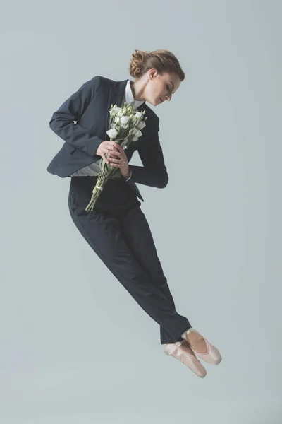 西装女实业家和芭蕾舞鞋跳跃与花束的花朵 在灰色隔离 — 图库照片