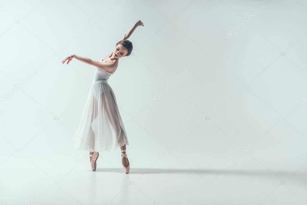 elegant ballerina dancing in studio, isolated on white