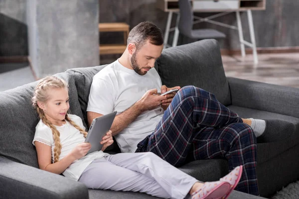 Vater und Tochter nutzen digitale Geräte — Stockfoto