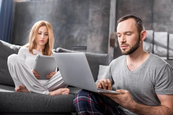 Paar nutzt digitale Geräte — Stockfoto