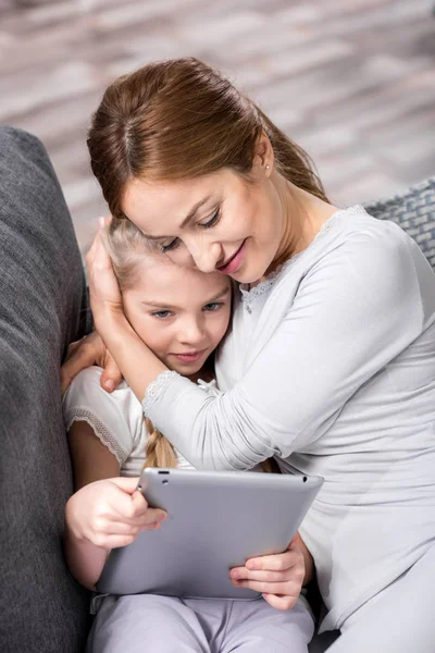 Madre e hija usando tableta digital - foto de stock