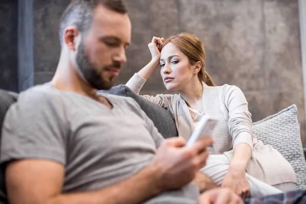 Jeune couple sur canapé — Photo de stock