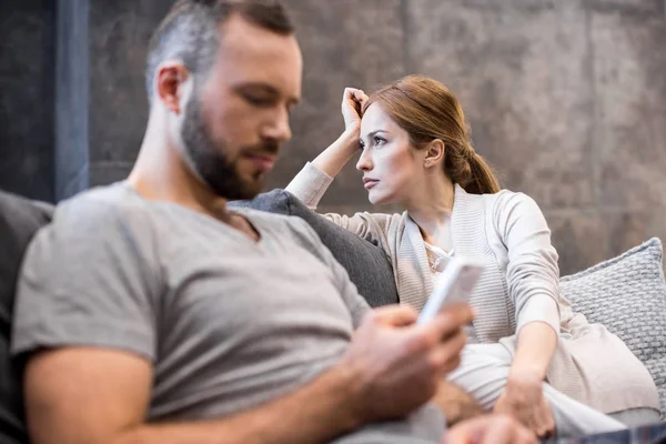 Jeune couple sur canapé — Photo de stock