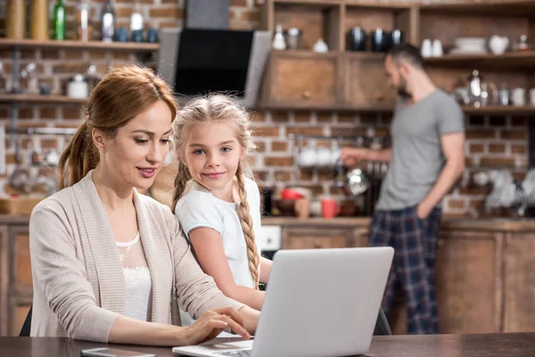 Mujer y niño con portátil - foto de stock