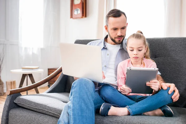 Pai e filha usando dispositivos — Fotografia de Stock