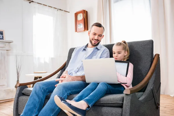 Padre e hija usando laptop - foto de stock