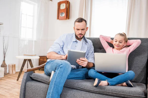 Father and daughter using devices — Stock Photo