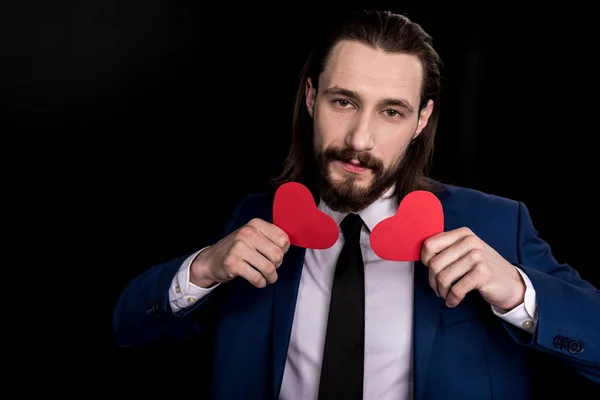 Hombre sosteniendo corazones de papel - foto de stock