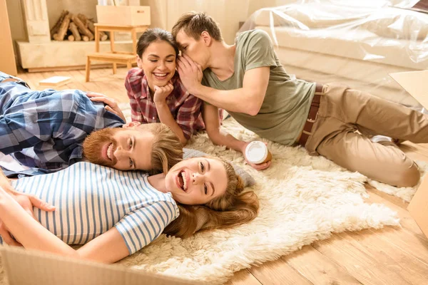 Friends lying on carpet — Stock Photo