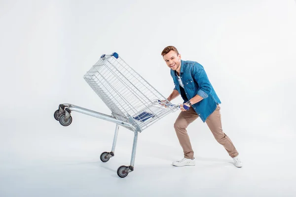 Young man with shopping trolley — Stock Photo