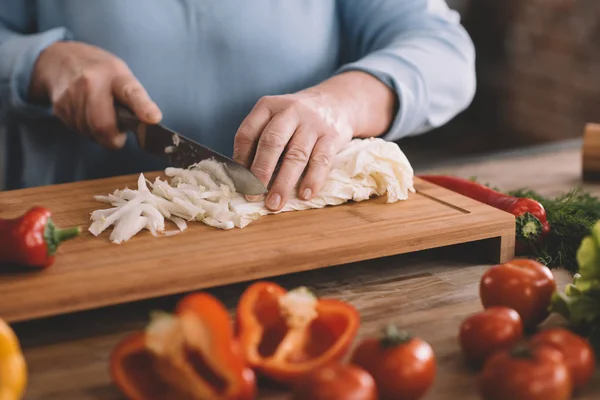 Seniorin schneidet Zwiebel — Stockfoto