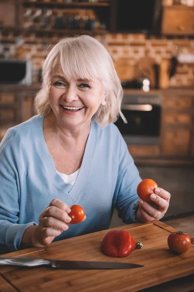 Senior woman with tomatoes — Stock Photo