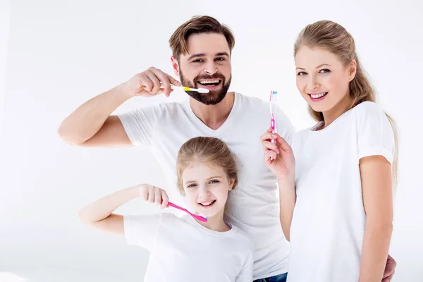 Family holding toothbrushes — Stock Photo