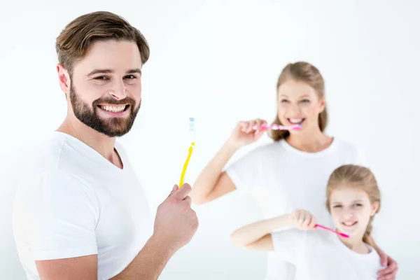 Family holding toothbrushes — Stock Photo