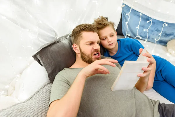 Padre e hijo leyendo libro - foto de stock