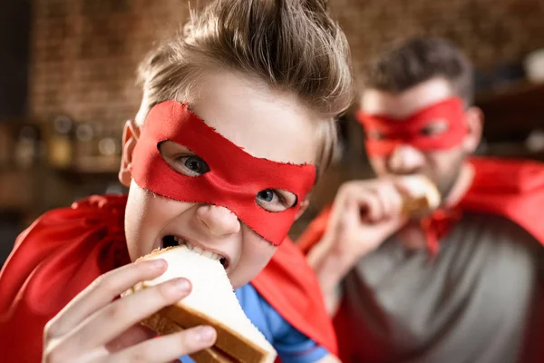 Pai e filho comendo sanduíches — Fotografia de Stock