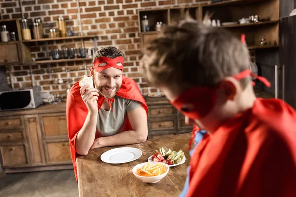 Father and son eating sandwiches — Stock Photo